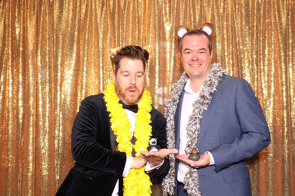 Bride and groom at the Posed photo booth with a gold sequin backdrop, Austin