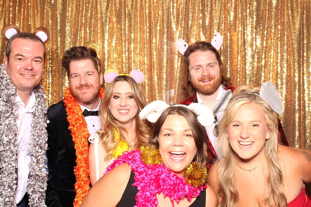 Group of friends with props at the Posed photo booth, Austin